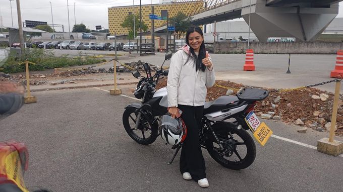Aluna aprovada ao lado da moto após tirar a habilitação na Preferencial Autoescola